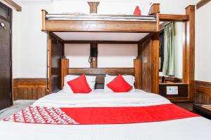 新德里Hotel Cottage Crown Plaza By My Rooms的一间卧室配有一张带红色枕头的大床