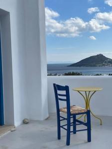 阿林达Villa Keroula的一张蓝色椅子,坐在桌子旁,享有海景