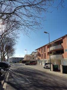 佩皮尼昂Joli appartement dans quartier calme de Perpignan的一条空荡荡的街道,有汽车停在停车场