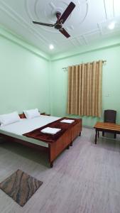 AyodhyaARJUN PAYING GUEST HOUSE的一间卧室配有一张床和吊扇