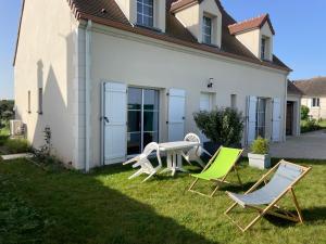 Mont-lʼEvêqueChambre d’hôte Chancelier Guerin的一个带两把草坪椅和桌子的院子
