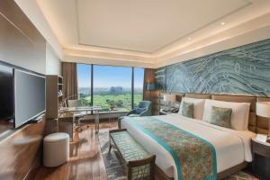 新德里新德里利拉格调会议酒店的酒店客房设有一张大床和一张书桌。