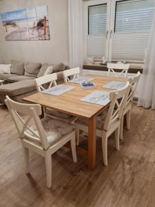 HageFerienwohnung Nordseetraum的客厅配有一张木桌和椅子