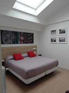 AzcoitiaBalentziaga的一间卧室配有一张带两个红色枕头的床