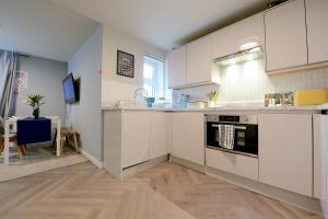 伦敦2 BEDROOM FLAT in WOOD GREEN PICCADILLY LINE的厨房配有白色橱柜和台面