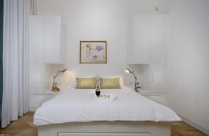 Poriyyaלוויט האוס的白色卧室配有一张带两盏灯的大白色床