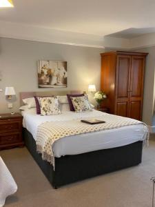 巴恩斯特珀尔斯平尼旅馆的一间卧室配有一张带鲜花的大床
