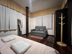 清迈Allred Hostel Chiangmai的一间卧室配有一张床、一个十字架和一把椅子