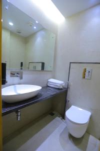 新德里Hotel The Glitz的一间带水槽、卫生间和镜子的浴室