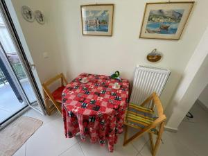 比雷埃夫斯Piraeus art deco apartment的一间设有桌子和椅子及红色桌布的房间