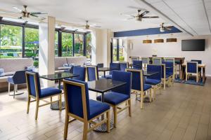 劳德代尔堡劳德代尔堡-塞普里斯克里克汉普顿酒店的一间配备有蓝色椅子和桌子的用餐室