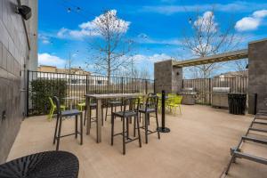 贝敦Home2 Suites By Hilton Baytown的一个带桌椅和围栏的庭院