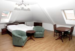 捷克特热博瓦Pivovar a restaurace Faltus的一间卧室配有一张床、两把椅子和一张桌子