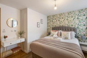 伦敦Tranquil Urban Haven的一间卧室配有一张带花卉壁纸的大床
