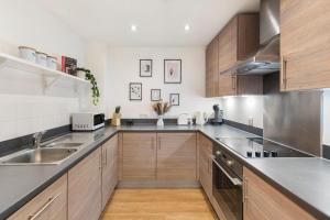 伦敦Tranquil Urban Haven的厨房配有不锈钢用具和木柜