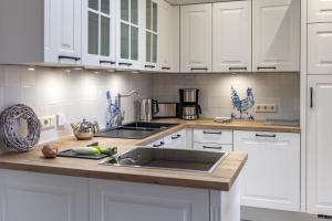 博尔库姆Commandeur-Huus Wohnung 1的厨房配有白色橱柜和水槽