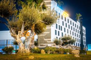 马拉加Hotel Málaga Vibes的一座建筑前有树的酒店