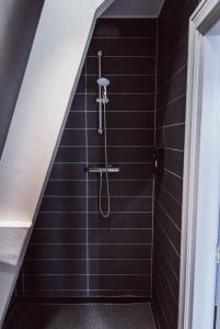 霍林赫姆Tres Boutique Hotel的浴室设有黑色瓷砖淋浴。