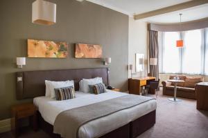 利兹The Met Hotel Leeds的酒店客房设有一张大床和一间客厅。
