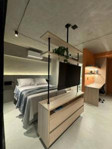 马里利亚Loft Marília City的一间卧室配有一张床和一台平面电视