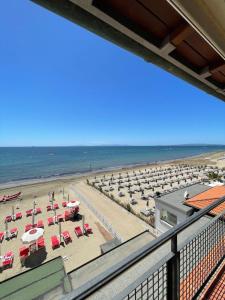 福洛尼卡Hotel Eden的享有带椅子和遮阳伞的海滩美景
