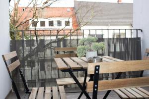 不莱梅Timeless Apartment Bremen-Neustadt的阳台上的木桌和椅子