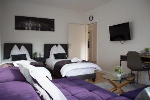 不莱梅Timeless Apartment Bremen-Neustadt的酒店客房,设有两张床和一张沙发