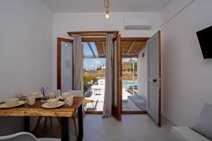 米克诺斯城Aqua Breeze Seaview Pool Suites Mykonos的一间设有桌子并享有泳池景致的用餐室