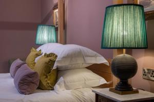 利特尔东海滩宾馆的一间卧室配有一张带枕头的床和两盏灯。