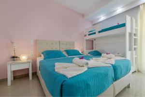 古维亚Palotel Design Gouvia的一间卧室配有两张带毛巾和一张双层床的床。
