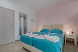 古维亚Palotel Design Gouvia的一间卧室配有蓝色的床和毛巾