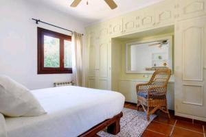 圣安东尼奥湾Authentic 4BR Pool & Sauna Villa, Sant Agusti的卧室配有床、椅子和窗户。