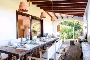 圣安东尼奥湾Authentic 4BR Pool & Sauna Villa, Sant Agusti的一间带长桌和椅子的用餐室