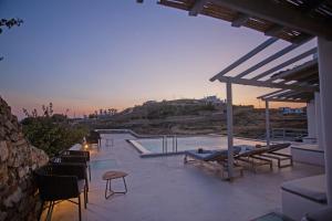 米克诺斯城Aqua Breeze Seaview Pool Suites Mykonos的一个带椅子的庭院和一个美景游泳池