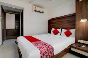 孟买Super OYO Flagship Hotel Everest Lodging Vashi的卧室配有带红色枕头的大型白色床