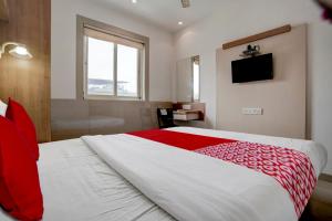 孟买Super OYO Flagship Hotel Everest Lodging Vashi的一间卧室配有一张带红色毯子的大床