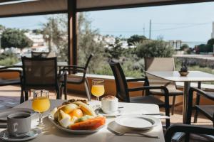 蓬塔普里马Hotel Xaloc Playa的一张桌子,上面放着一盘食物和一杯橙汁