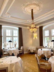 艾珍明希豪森城堡酒店的一间带桌子和吊灯的用餐室