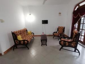 波隆纳鲁沃Sunshine Guest House的带沙发、椅子和电视的客厅