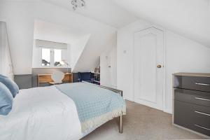 亨利昂泰晤士Charming 3 Bedroom Townhouse in Henley-On-Thames的白色卧室配有床和书桌