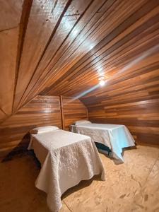 本图贡萨尔维斯Vale dos Imigrantes的小木屋内带两张床的房间