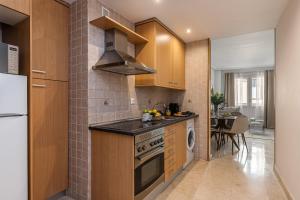 马德里BNBHolder Loving Gran Via Apartment IV的厨房配有木制橱柜和炉灶烤箱。