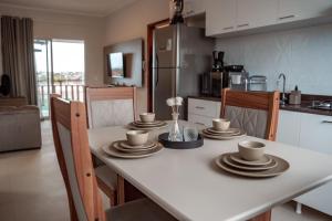 卡诺格布拉达Quality - Boas Vistas的厨房里设有桌子,上面有盘子和杯子