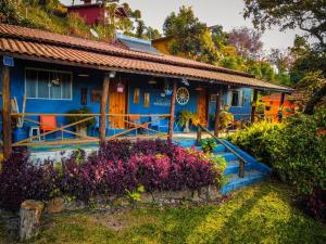 CostasChalés lá na roça的前面有鲜花的蓝色房子