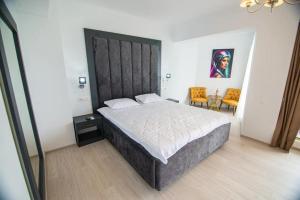 科斯蒂内什蒂Alessio Hotel Residence的一间卧室配有一张大床和大床头板
