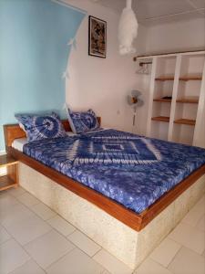 Diakène OuolofCAMPEMENT DIAMORAL DIAKENE OULOFF的一间卧室配有一张带蓝色棉被的床