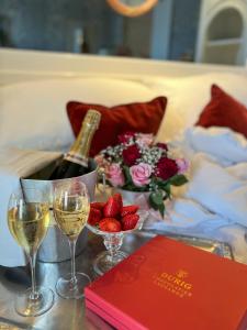 洛桑洛桑卡尔顿精品酒店的一张桌子,上面放着一瓶葡萄酒、酒杯和草莓
