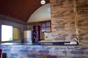 阿布辛贝Kony Nubian Guest House的厨房设有砖墙和冰箱。