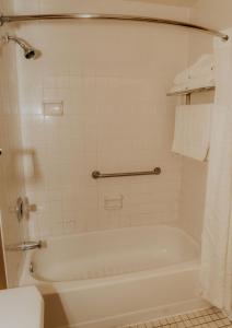 华莱士华莱士宾馆的浴室配有白色浴缸和卫生间。