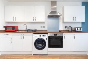 考文垂1BR Hideaway in Coventry - MH Apartment的厨房配有洗衣机和微波炉。
